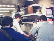 The nose cone being machined, while film crew look on
